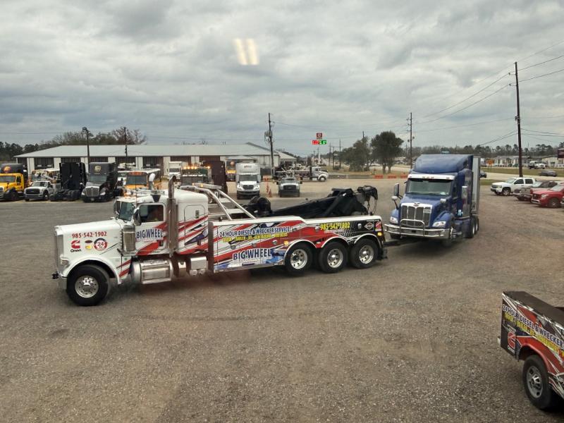 photo shows Big Wheel Wrecker Service wrecker towing a semi truck